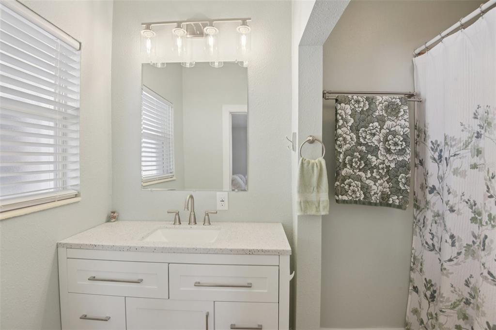 204 160th Avenue Redington Beach, FL 33708 - Photo 15 of 32 a bathroom with a granite countertop sink a shower and a mirror