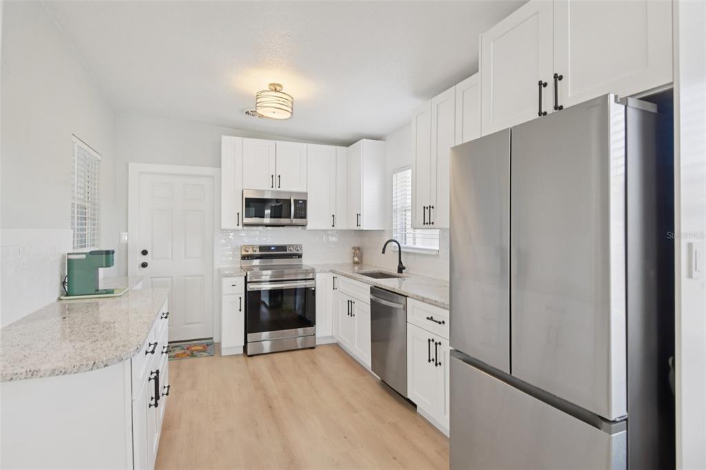 204 160th Avenue Redington Beach, FL 33708 - Photo 4 of 32 a kitchen with stainless steel appliances white cabinets and a refrigerator