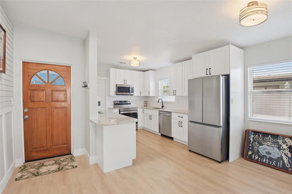 204 160th Avenue Redington Beach, FL 33708 - Photo 5 of 32 a kitchen with white cabinets and stainless steel appliances