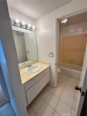 a bathroom with a sink a toilet a mirror and shower