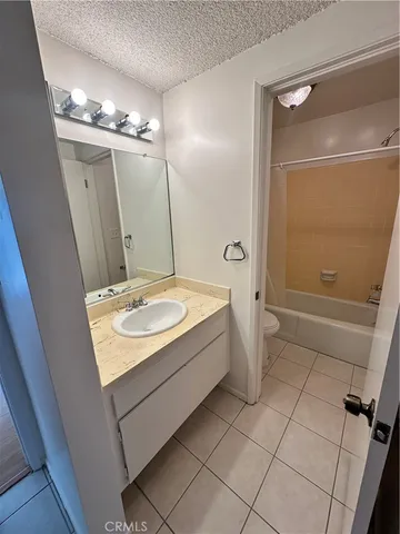 a bathroom with a sink a toilet a mirror and shower