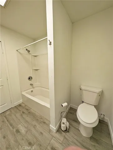a white toilet sitting next to a bath tub and a shower