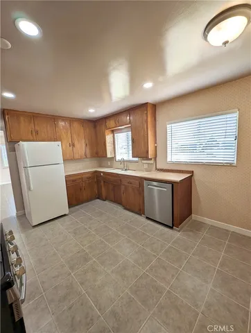 a kitchen with stainless steel appliances a refrigerator sink and cabinets