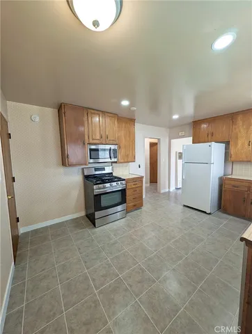 a kitchen with a refrigerator and a stove top oven