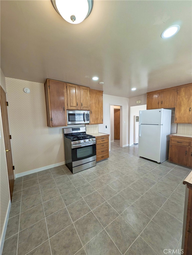 379 North 3rd Street Grover Beach, CA 93433 - Photo 7 of 24 a kitchen with a refrigerator and a stove top oven