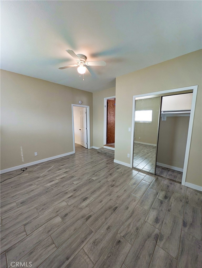 379 North 3rd Street Grover Beach, CA 93433 - Photo 8 of 24 an empty room with wooden floor and mirror on ceiling fan