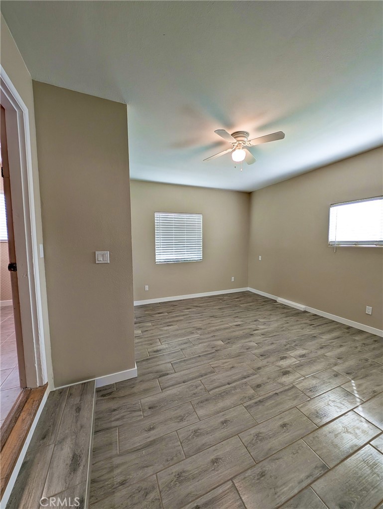 379 North 3rd Street Grover Beach, CA 93433 - Photo 10 of 24 an empty room with wooden floor and a ceiling fan