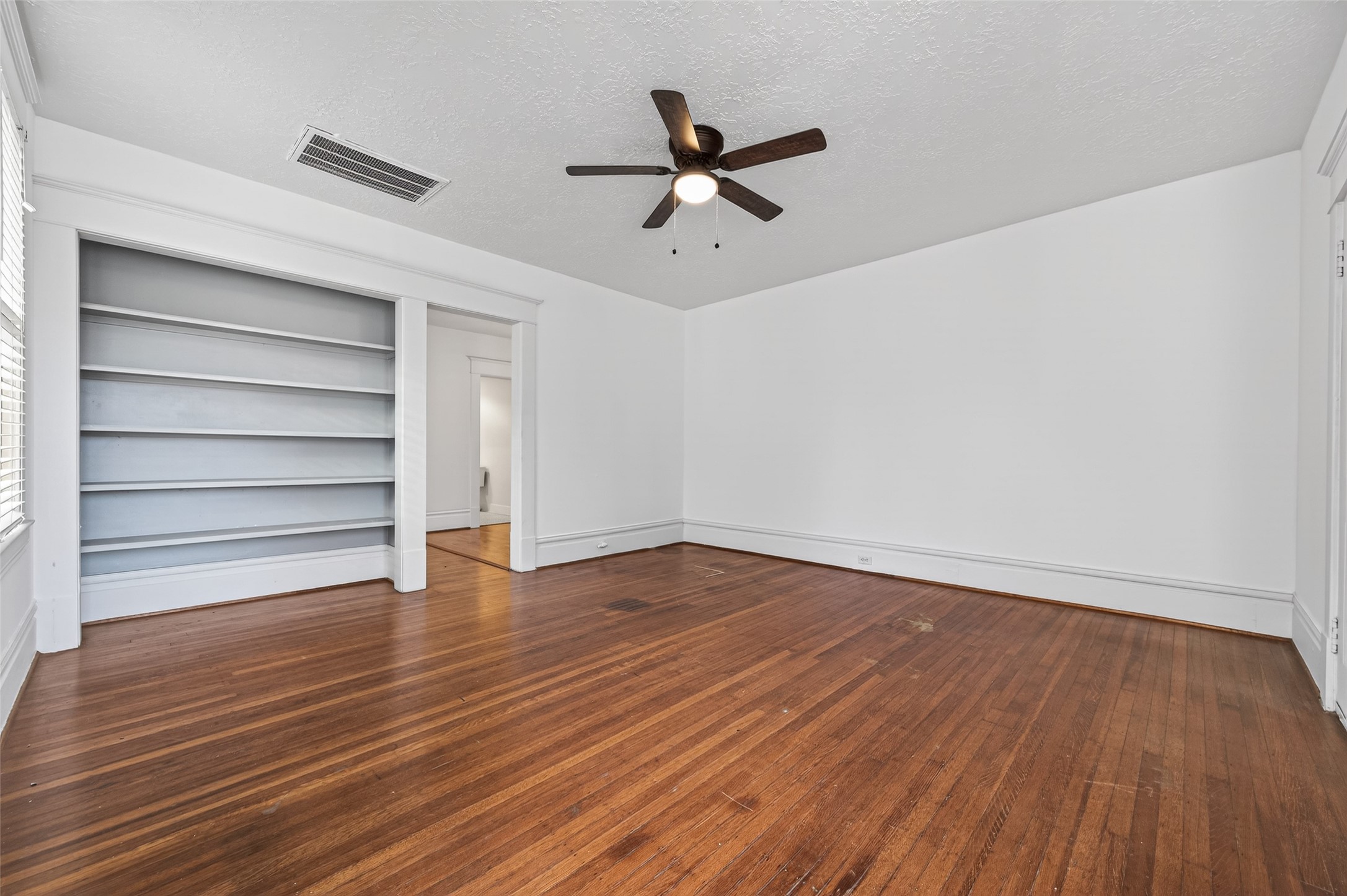 324 West Alabama Street, Unit 1 Houston, TX 77006 - Photo 17 of 30 a view of an empty room with wooden floor and a ceiling fan