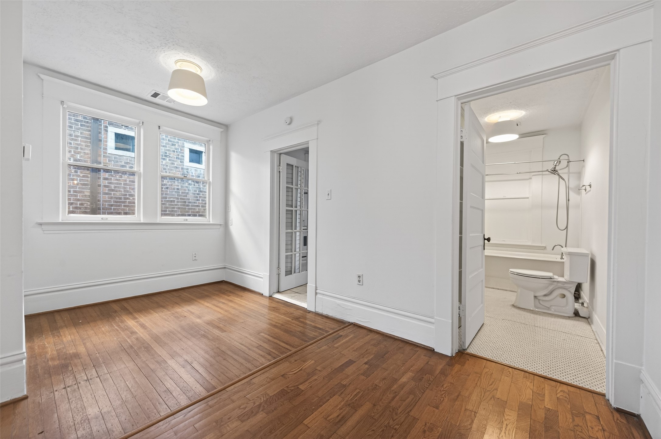 324 West Alabama Street, Unit 1 Houston, TX 77006 - Photo 7 of 30 an empty room with wooden floor and windows