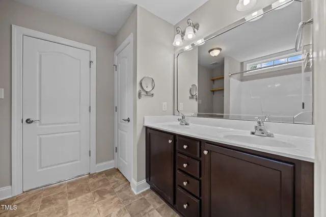 a bathroom with a double vanity sink and a mirror