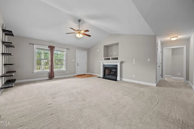 an empty room with windows and ceiling fan