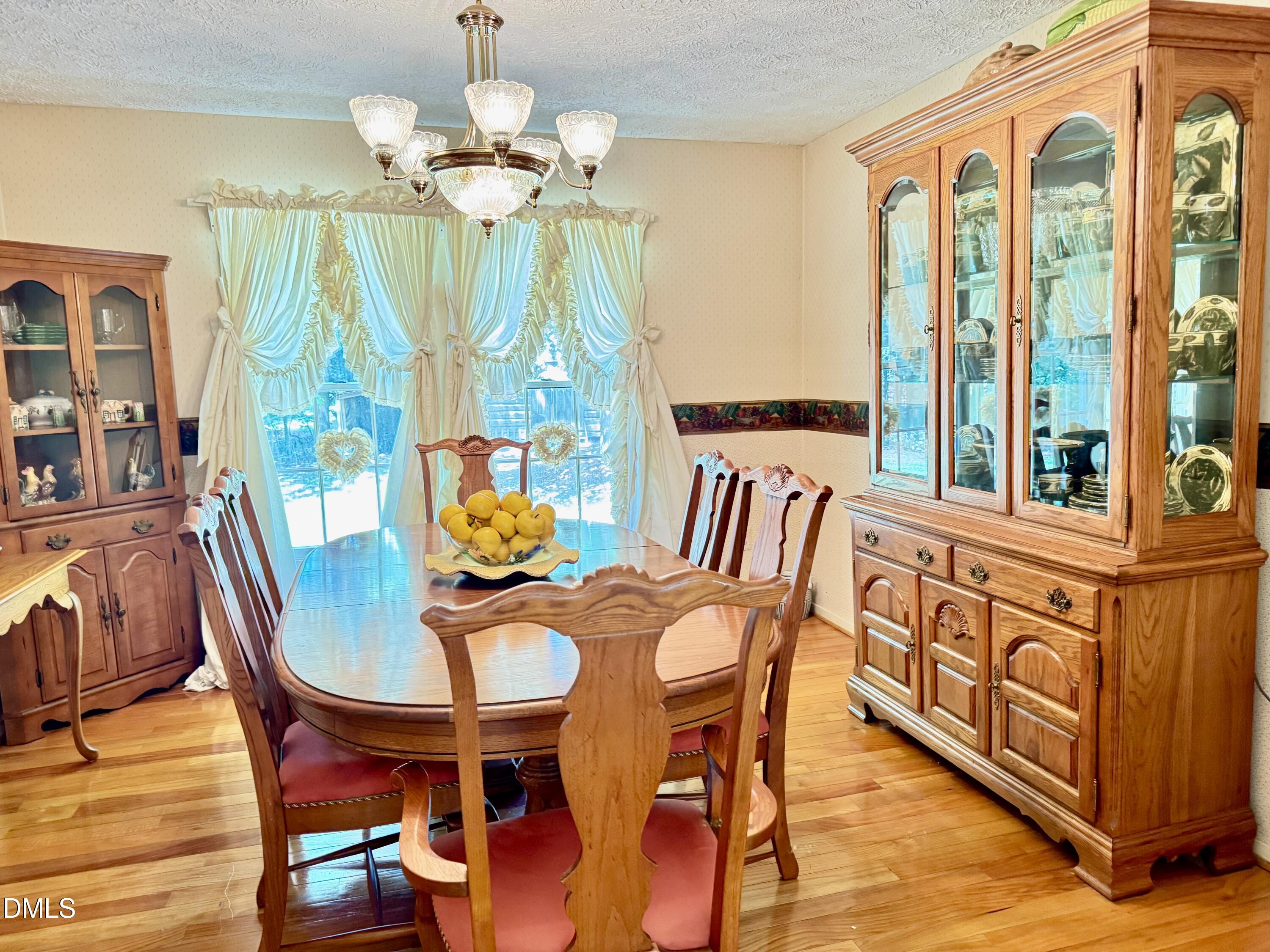 84 Wintergreen Road Henderson, NC 27537 - Photo 14 of 49 a dining room with furniture a chandelier and wooden floor