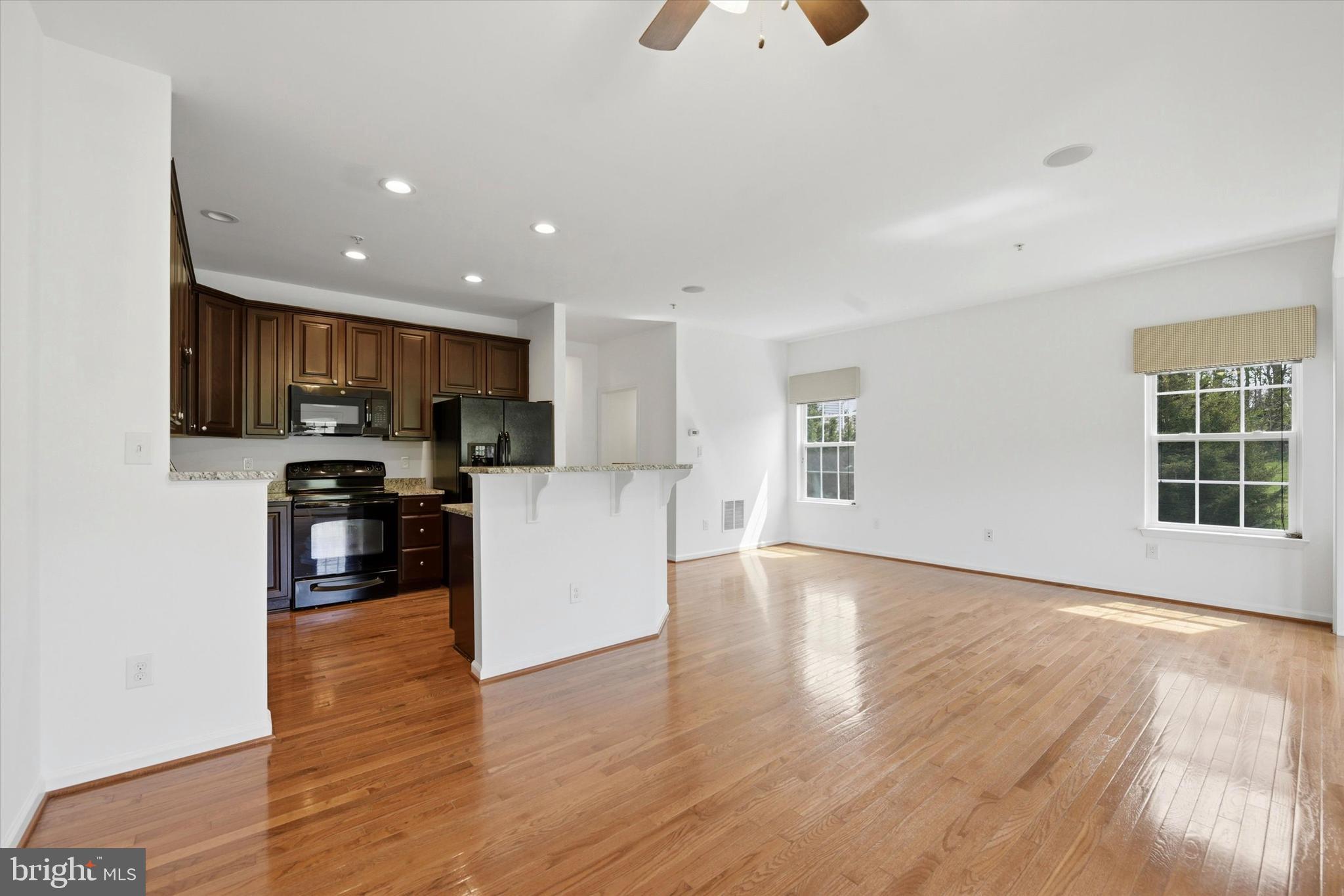 186 Tulsk Road Avondale, PA 19311 - Photo 14 of 38 a kitchen with stainless steel appliances granite countertop a stove a refrigerator a sink a microwave oven with wooden cabinets and wooden floor