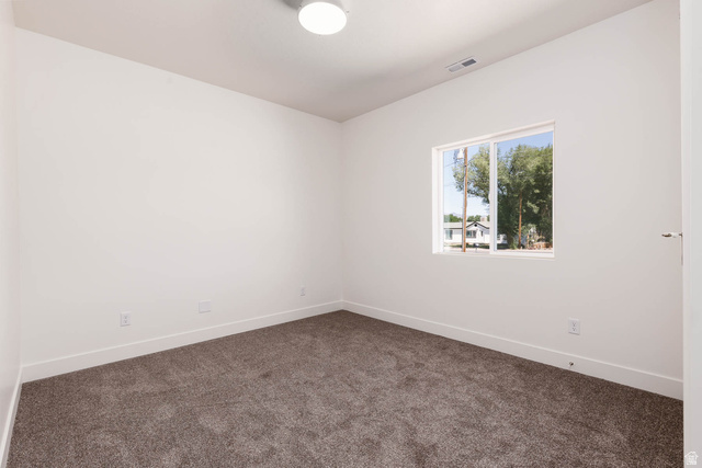 51 West 500 South Monroe, UT 84754 - Photo 7 of 41 Light-filled room featuring a double-pane window, neutral carpet, white baseboards, and a flush-mount ceiling light fixture