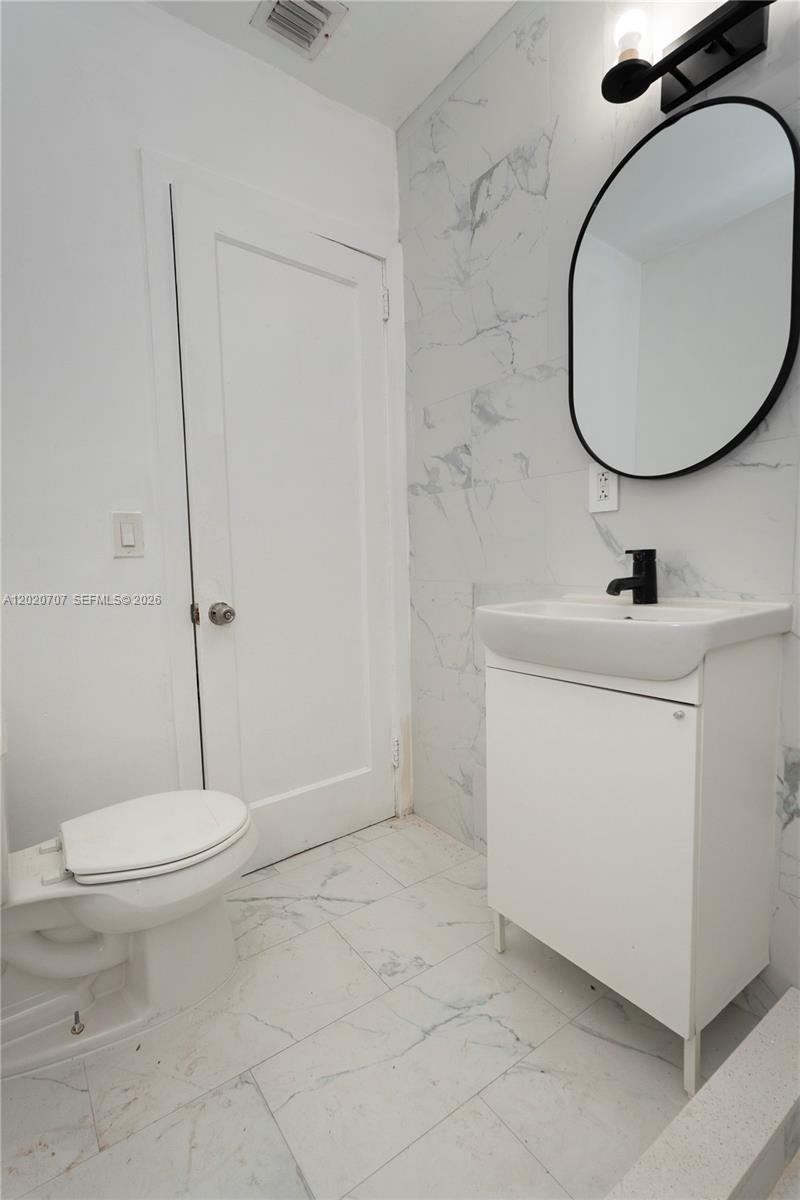 111 Southwest 31st Court, Unit 1 Miami, FL 33135 - Photo 4 of 13 a bathroom with a sink a toilet and a mirror