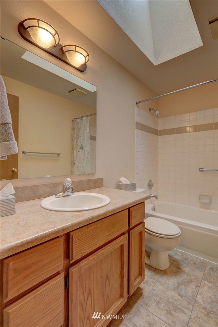 5142 South Garden Loop Road Seattle, WA 98118 - Photo 18 of 18 a bathroom with a granite countertop sink a toilet and a mirror