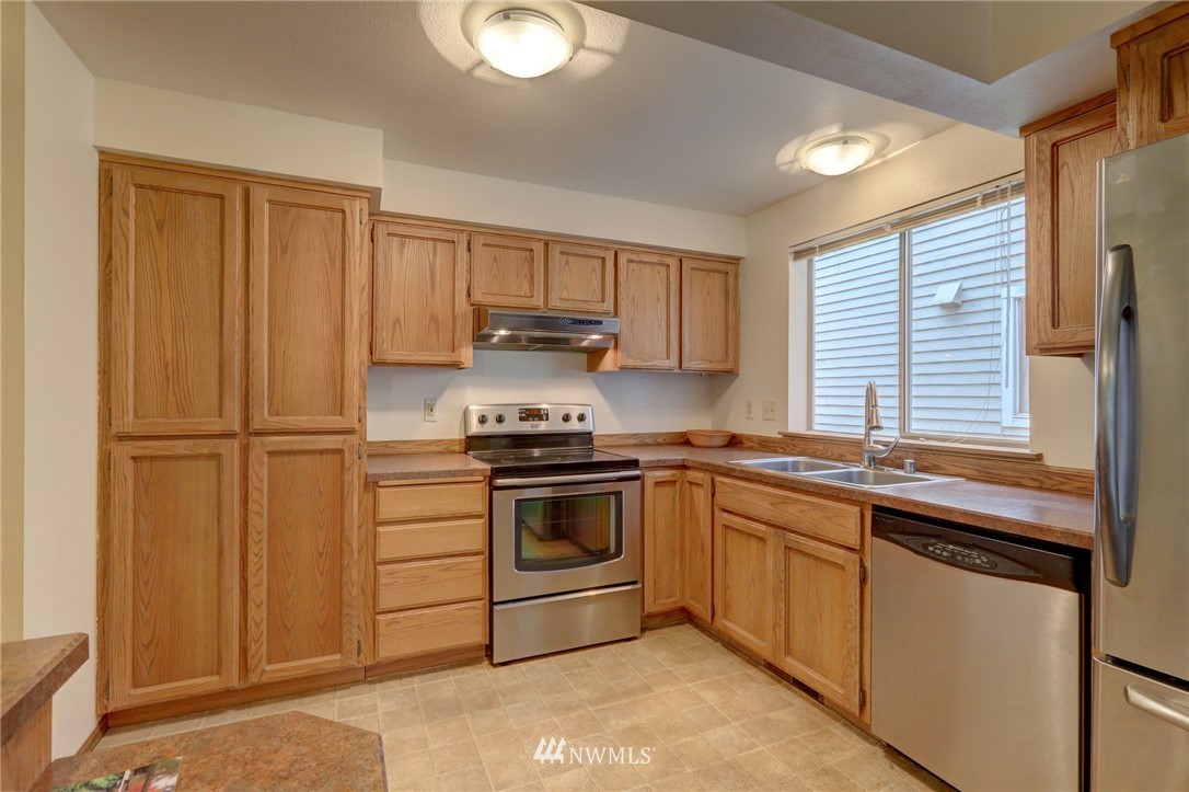 5142 South Garden Loop Road Seattle, WA 98118 - Photo 5 of 18 a kitchen with a sink stove and microwave