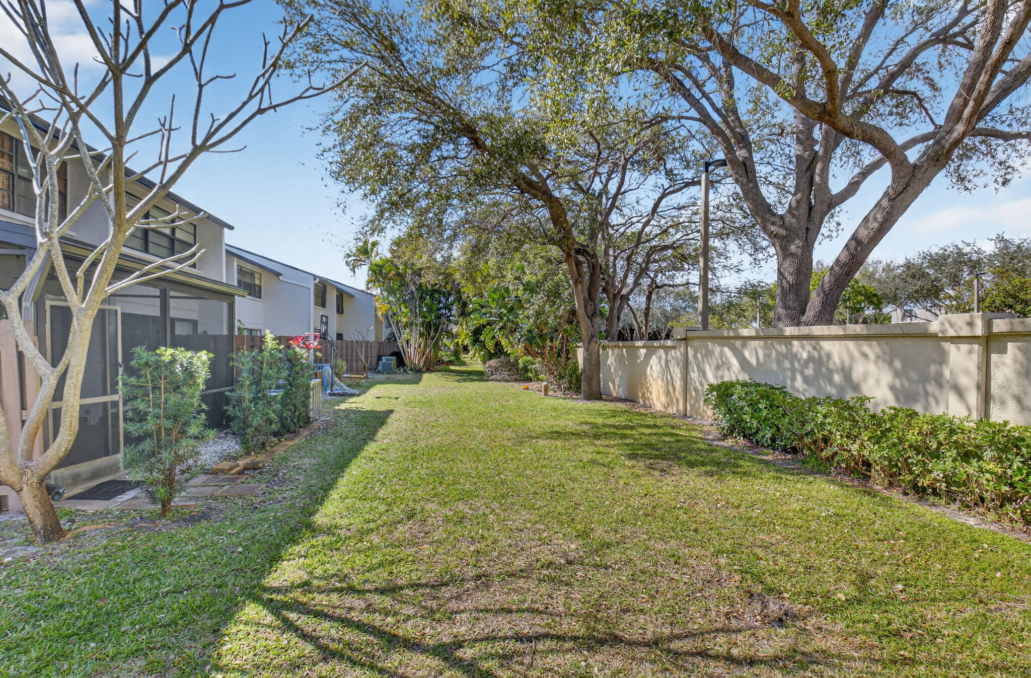 4761 Northwest 2nd Avenue, Unit 301 Boca Raton, FL 33431 - Photo 32 of 56 a view of a backyard with large trees