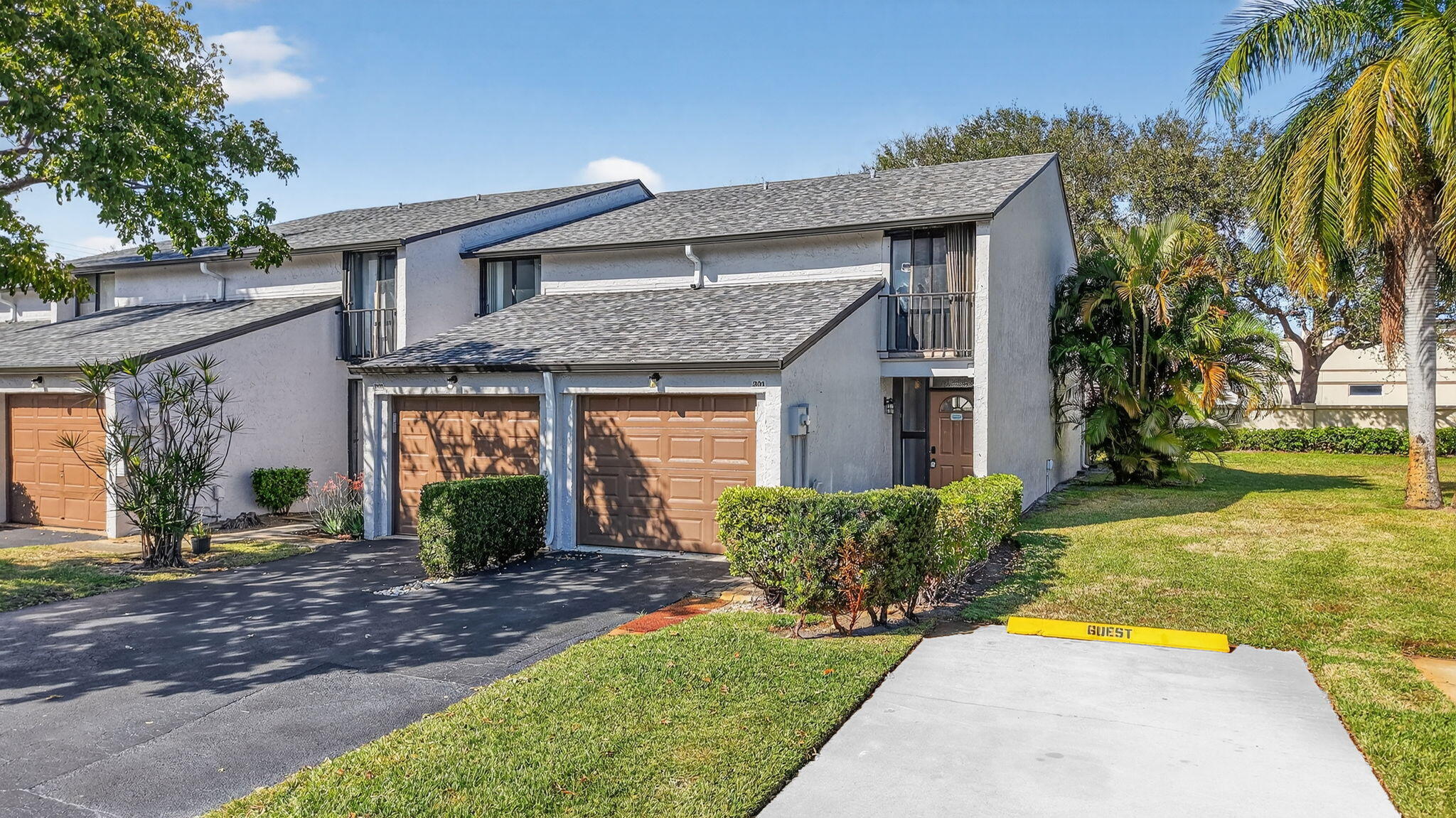 4761 Northwest 2nd Avenue, Unit 301 Boca Raton, FL 33431 - Photo 45 of 56 a front view of a house with a yard and potted plants