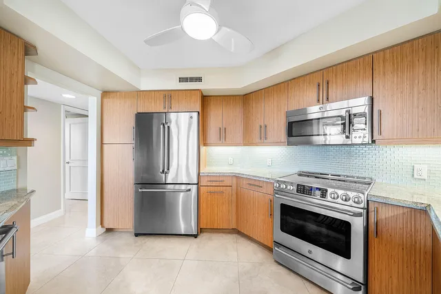 a kitchen with stainless steel appliances granite countertop a stove a refrigerator and a microwave