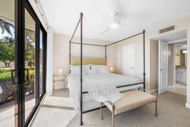 a bedroom with a bed and large window with glass door