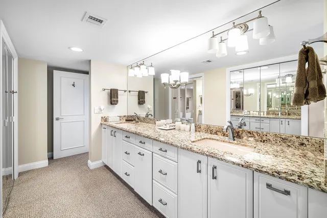 a bathroom with a granite countertop double sink and a mirror
