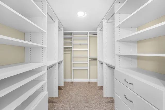 a view of walk in closet with empty racks
