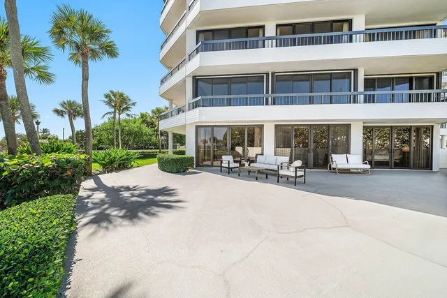 a patio with a table and chairs under an umbrella