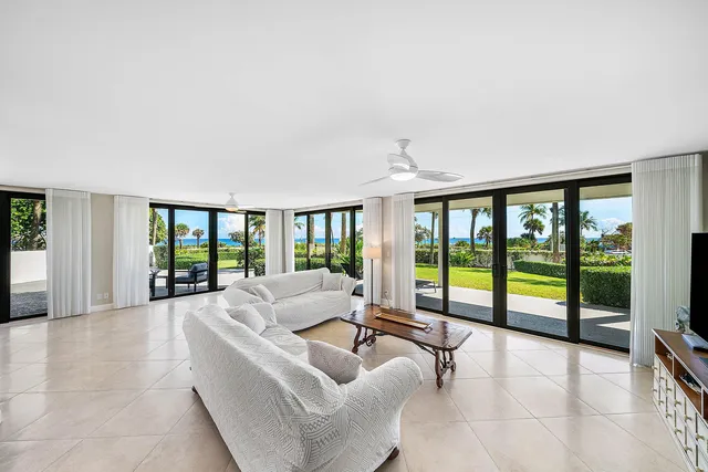 a living room with furniture and large windows with outer view