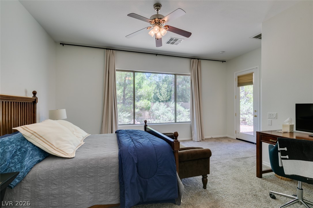 8 Kennesaw Road Henderson, NV 89052 - Photo 32 of 44 A well-lit primary bedroom offers plush carpeting and a private exit to the outdoors.