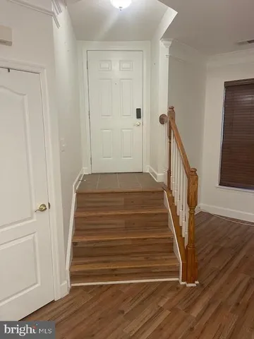 a view of a hallway with wooden floor and staircase