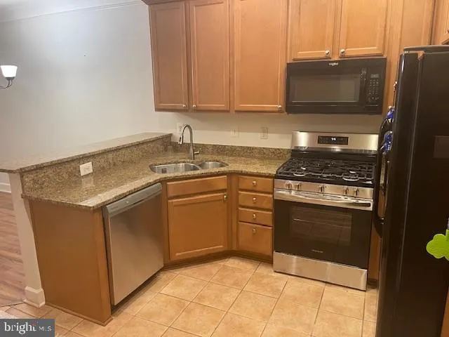 a kitchen with stainless steel appliances granite countertop a stove a microwave and a refrigerator