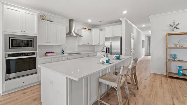 a dining room with furniture a wooden floor and kitchen view
