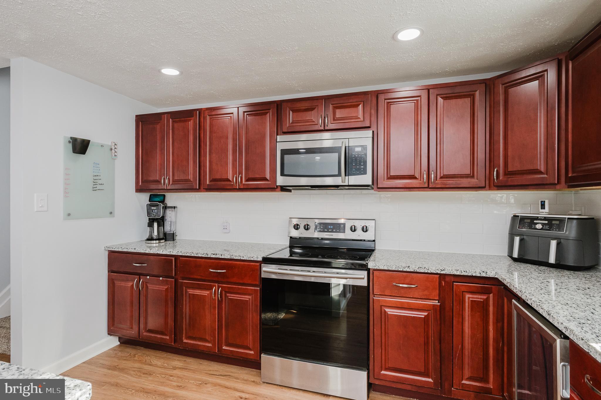 930 Edmund Street Aberdeen, MD 21001 - Photo 13 of 61 a kitchen with stainless steel appliances granite countertop wooden cabinets a stove top oven a sink and dishwasher with wooden floor