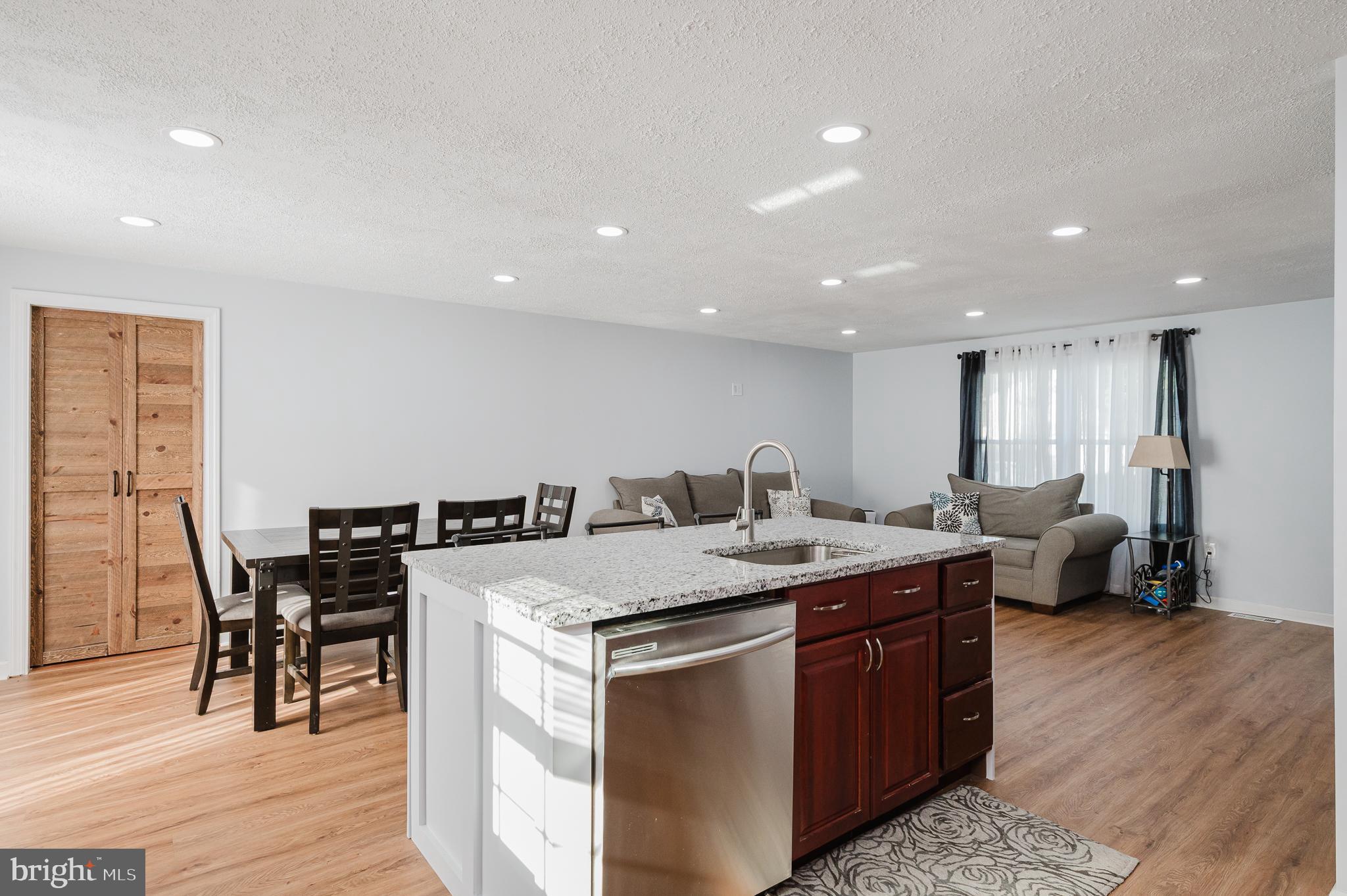 930 Edmund Street Aberdeen, MD 21001 - Photo 16 of 61 a kitchen with a stove a sink a dining table and chairs