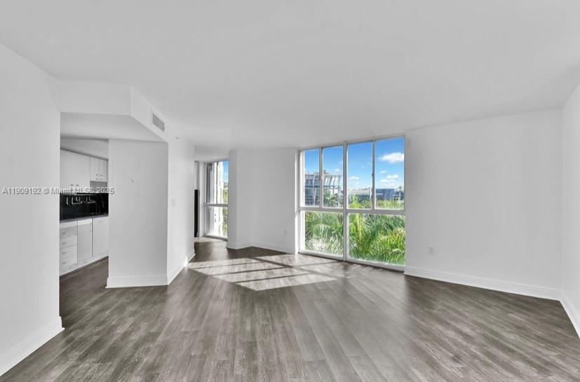 1688 West Avenue, Unit 602 Miami Beach, FL 33139 - Photo 15 of 61 a view of an empty room with wooden floor and a window