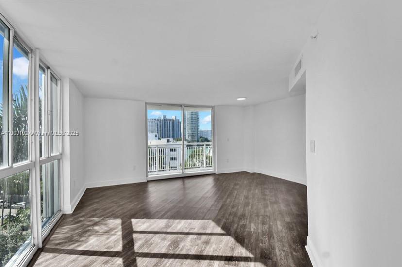 1688 West Avenue, Unit 602 Miami Beach, FL 33139 - Photo 19 of 61 a view of an empty room with wooden floor and a window