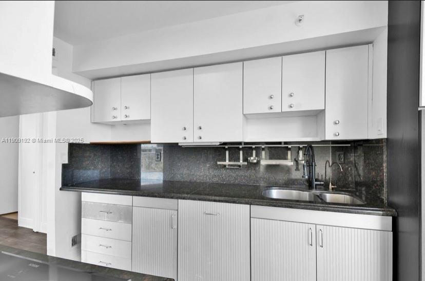 1688 West Avenue, Unit 602 Miami Beach, FL 33139 - Photo 26 of 61 a kitchen with granite countertop white cabinets and a sink
