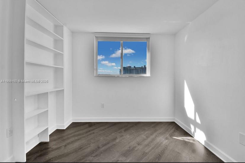 1688 West Avenue, Unit 602 Miami Beach, FL 33139 - Photo 46 of 61 a view of an empty room with wooden floor and a window