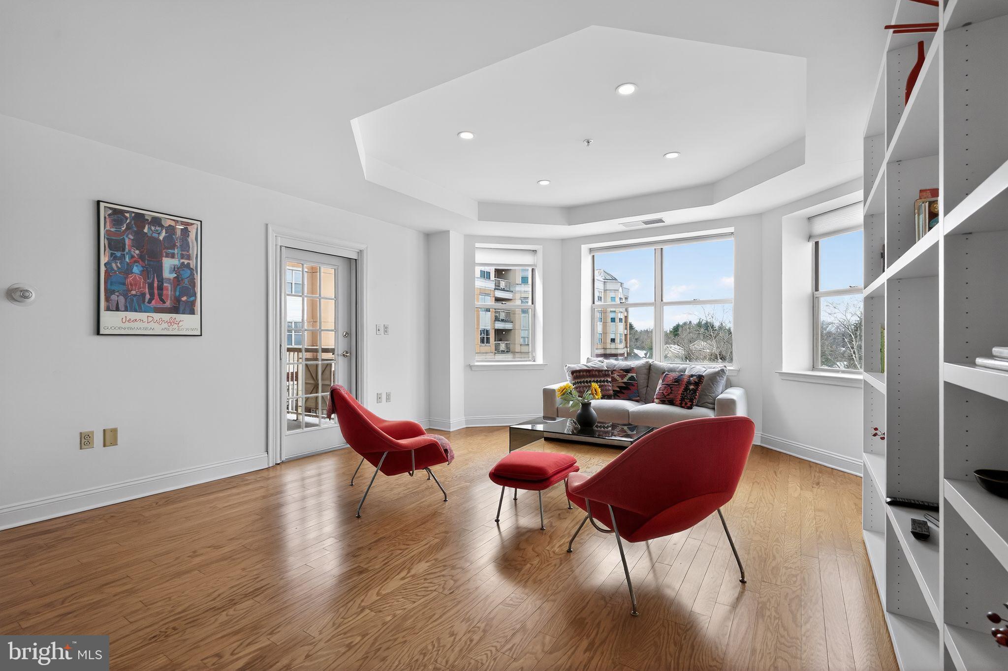 a living room with furniture a wooden floor and a large window