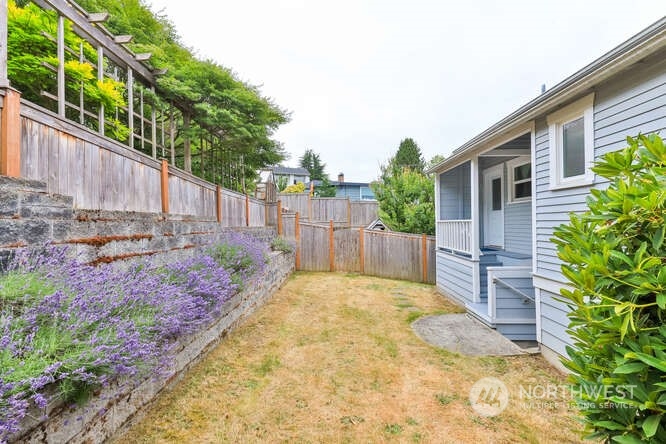 9340 45th Avenue Southwest Seattle, WA 98136 - Photo 17 of 33 a view of a backyard with large trees and wooden fence