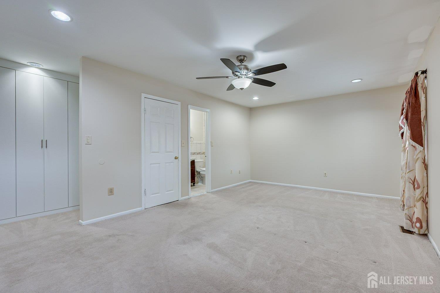7 Lily Court Edison, NJ 08820 - Photo 17 of 32 an empty room with a ceiling fan and a window