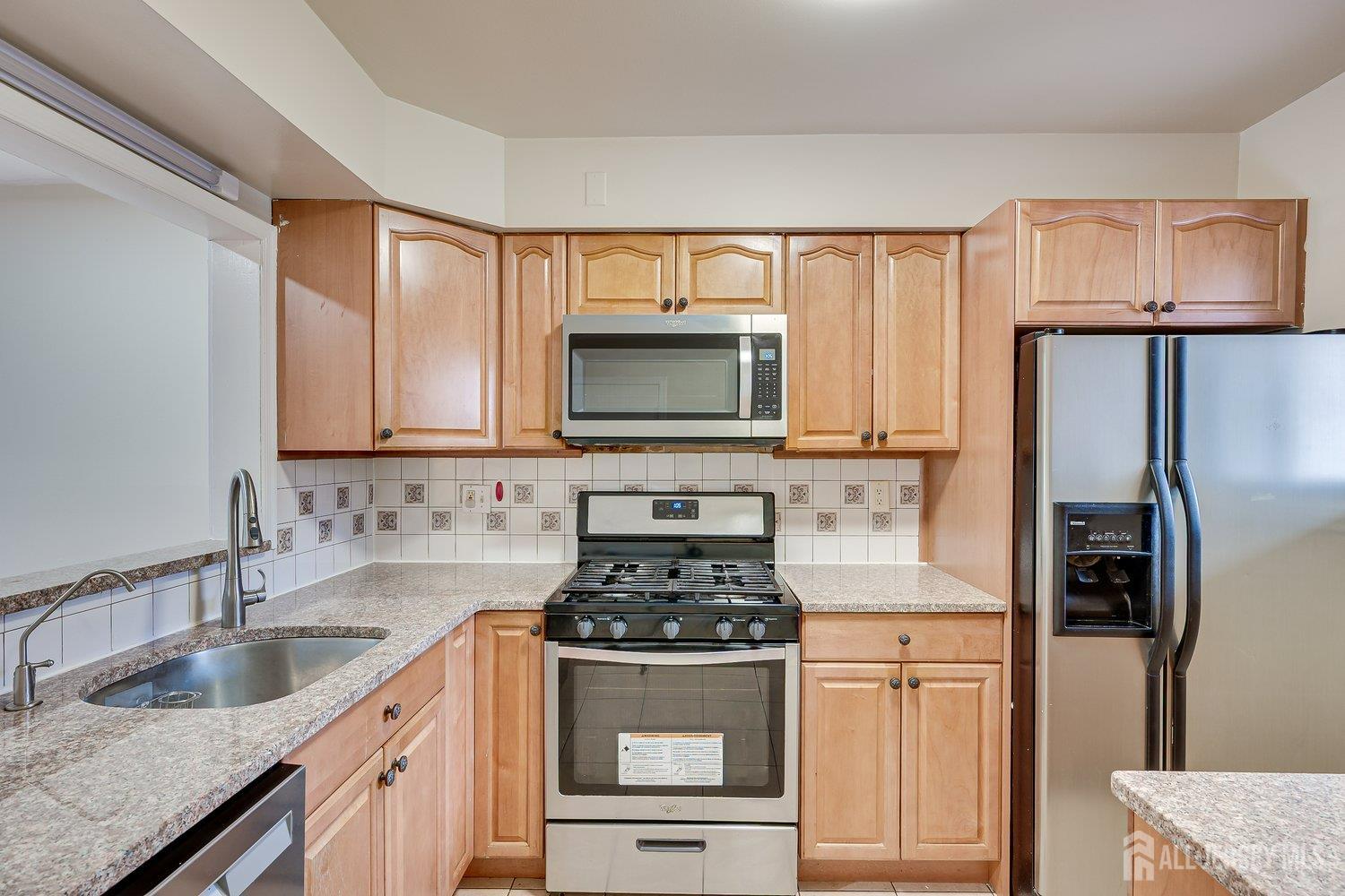 7 Lily Court Edison, NJ 08820 - Photo 4 of 32 a kitchen with stainless steel appliances a stove a microwave and a refrigerator