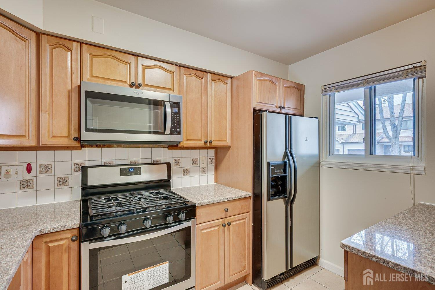 7 Lily Court Edison, NJ 08820 - Photo 5 of 32 a kitchen with stainless steel appliances granite countertop a refrigerator stove and microwave