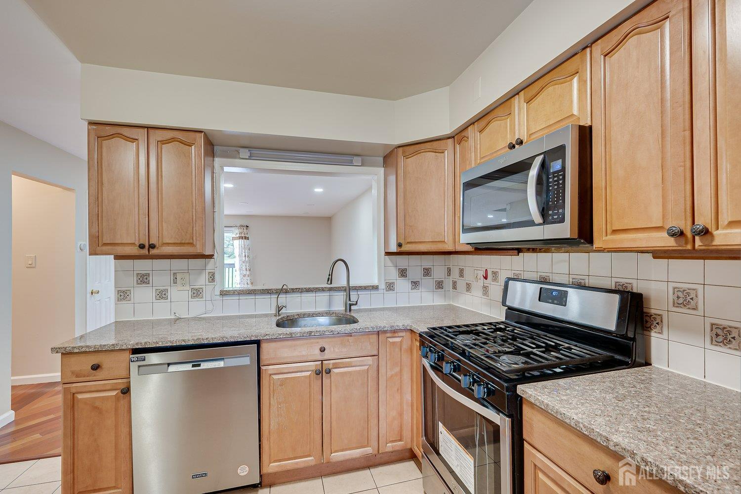 7 Lily Court Edison, NJ 08820 - Photo 6 of 32 a kitchen with stainless steel appliances granite countertop a sink stove and cabinets
