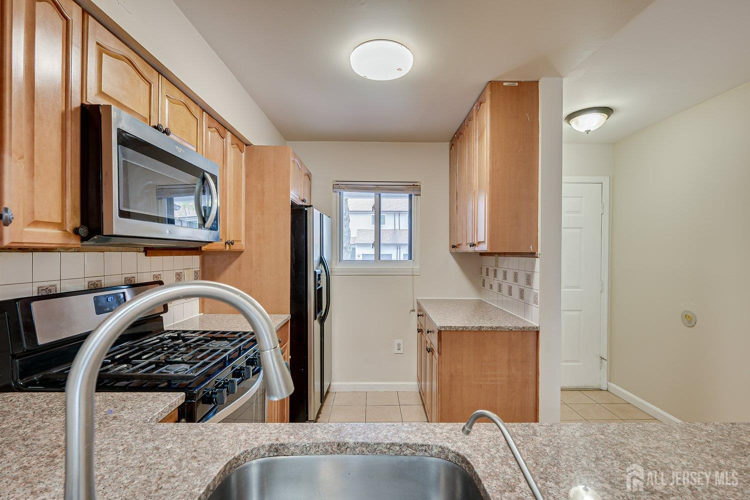 7 Lily Court Edison, NJ 08820 - Photo 7 of 32 a kitchen with stainless steel appliances granite countertop a stove a sink and a microwave