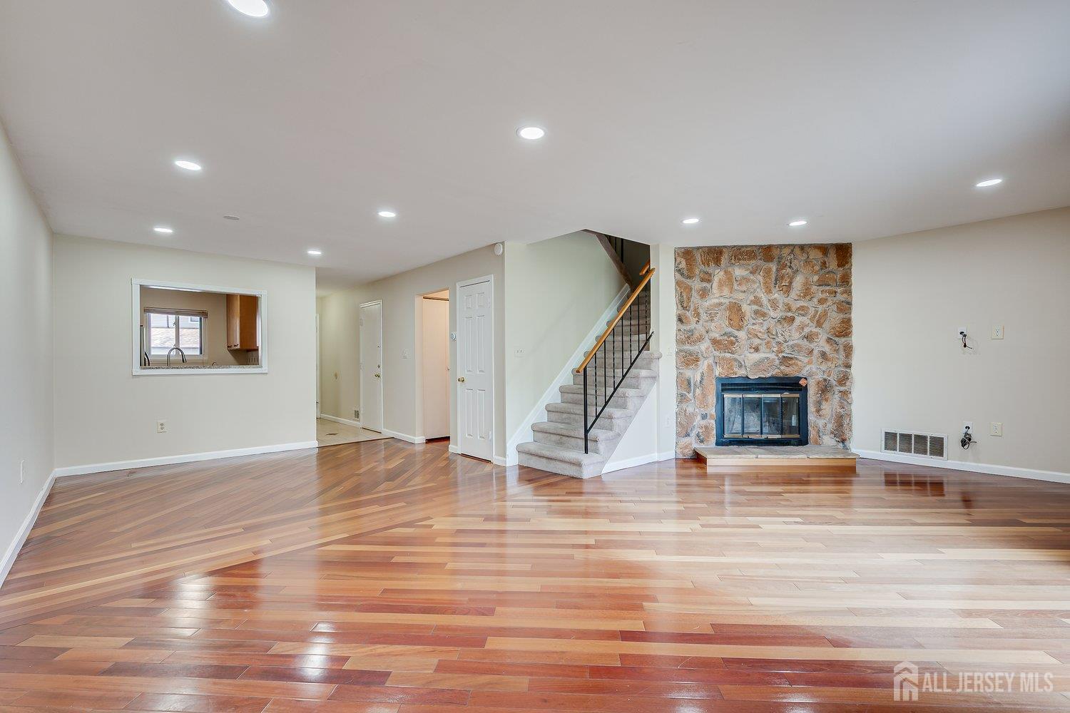 7 Lily Court Edison, NJ 08820 - Photo 10 of 32 a view of an empty room with wooden floor and a fireplace
