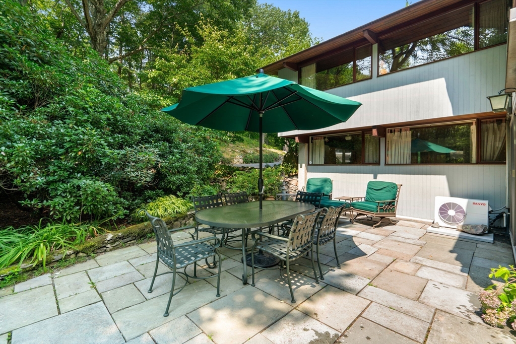 60 Pine Street Dover, MA 02030 - Photo 2 of 36 a view of a patio with a table and chairs under an umbrella