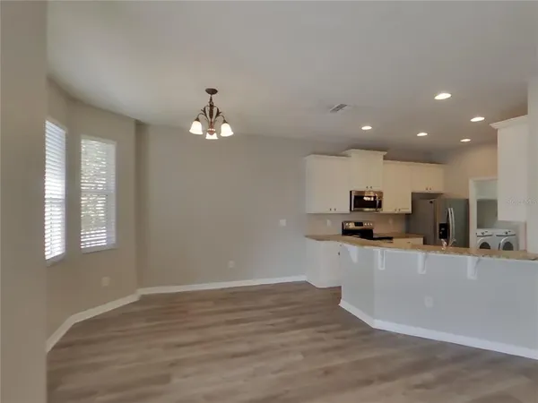 a kitchen with stainless steel appliances a sink a stove a refrigerator and a window