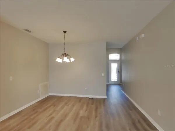 a view of a room with window and hardwood floor